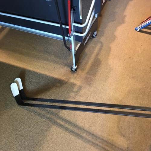 Two Blacked Out Pro stock Hockey Sticks