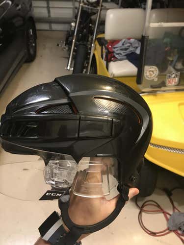 CCM Helmet with custom black inserts and a orange outline. CCM quick revision visor