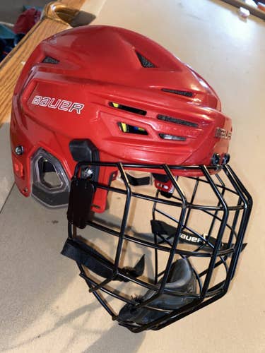 Red Used Medium Bauer Re-Akt 150 Helmet Paired with a black profile 2 cage