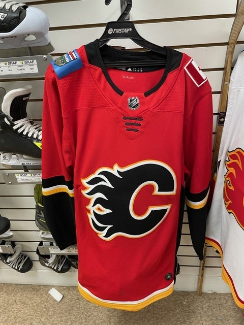 Tickle Trunk Thrift Store - Brand New Women's Calgary Flames Jersey. $20.  Size XL.