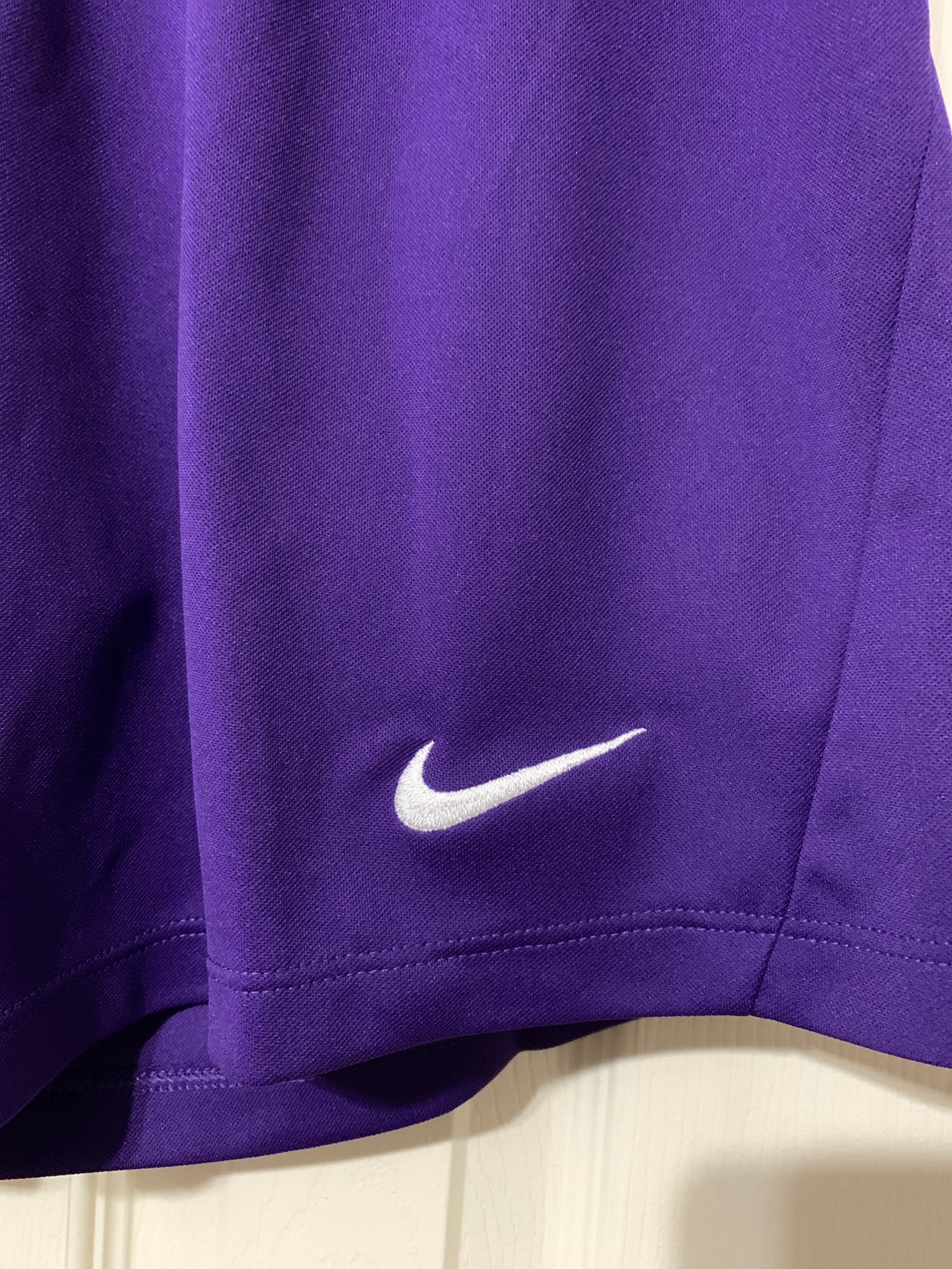 Man in purple nike soccer jersey shirt and black shorts running on