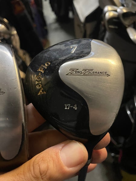 Zero tolerance golf driver and 7 wood in right Hand