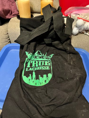 One large black and green True Lacrosse Bag