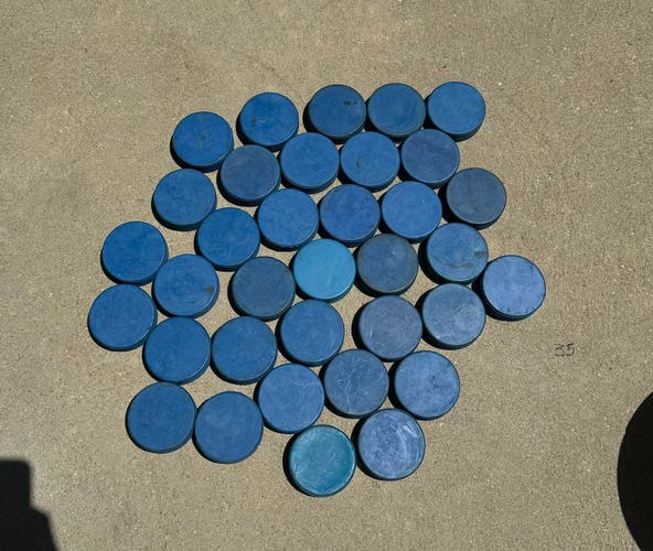 35 Blue hockey pucks