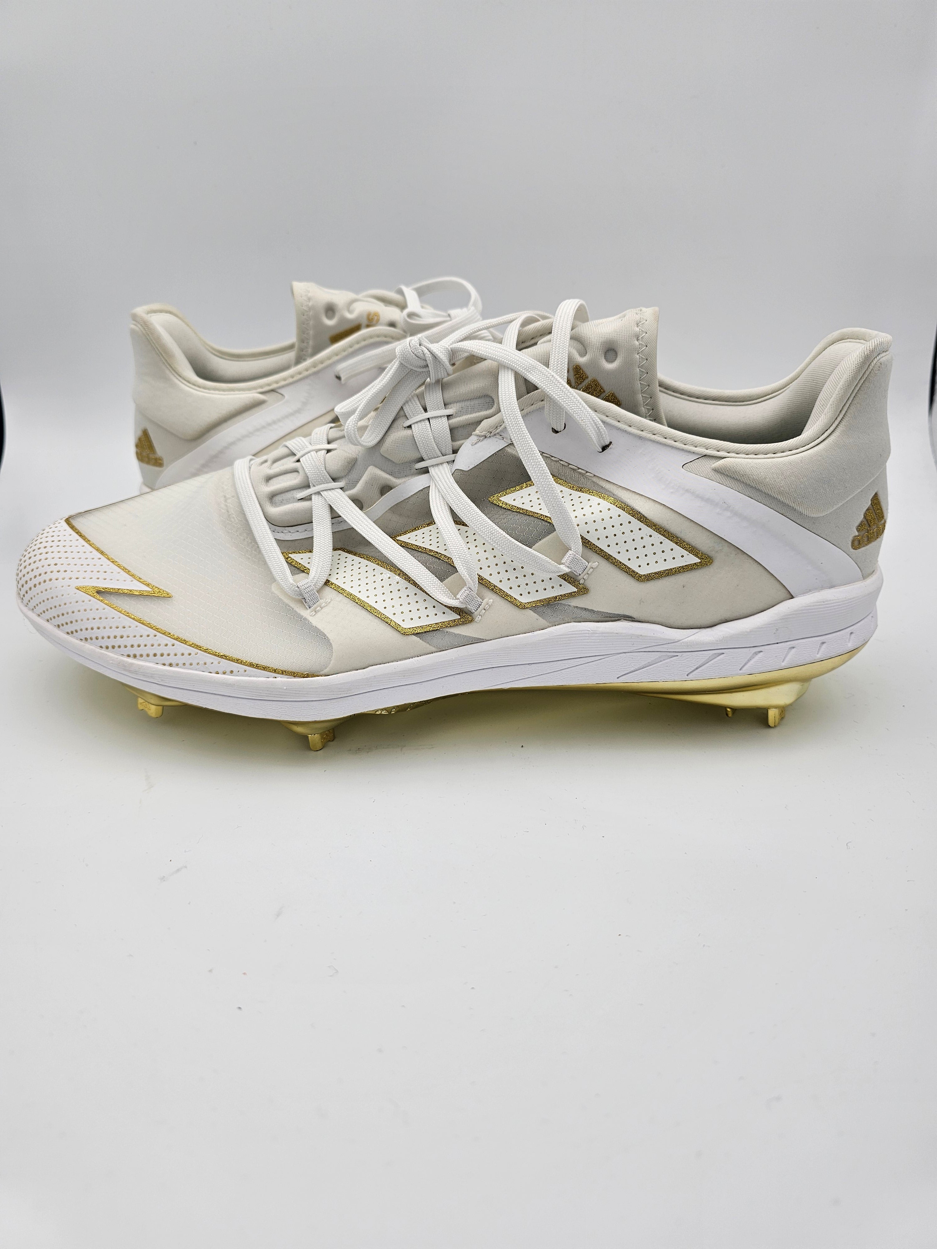 white and gold metal baseball cleats