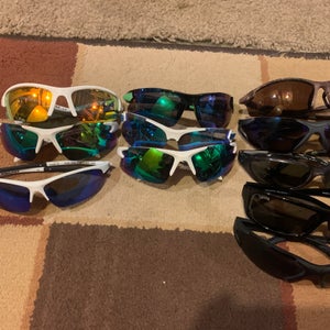 11 pairs of youth baseball sunglasses. various brands. alot of rawlings