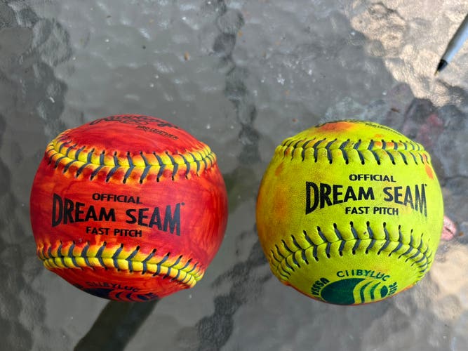 (Used) 2 Rawlings Dream Seam 1/2 red colored 11” softballs - used for pitching