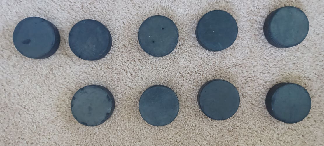 18 used and blemished hockey pucks