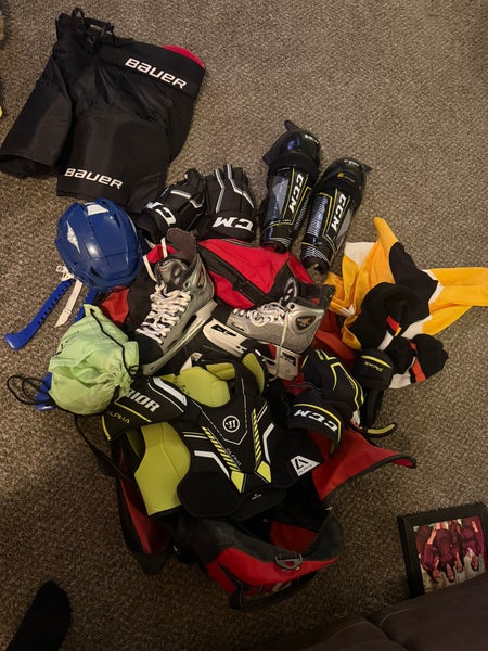 Full hockey gear with bag plus skates and a bag of pucks