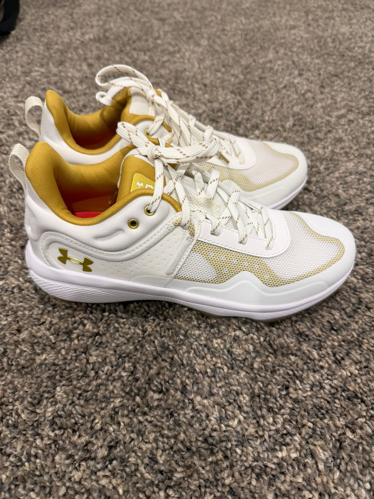 white and gold metal softball cleats