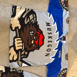 Awesome Muskegon Lumberjacks USHL Gray / Blue X-Large Adult Unisex Jersey (New) with graphics on bac