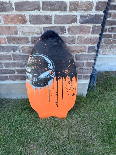 Skimboard: Skim Wizard brand skimboard with an orange and black drip design and a skull graphic.