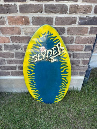Skimboard: Slyder "Skim to Live" wooden skimboard with yellow and blue graphics.