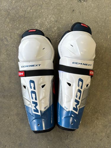 CCM Next 11” Junior Hockey Shin Guards – White/Blue