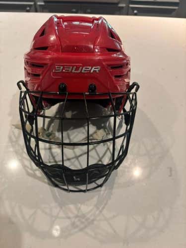Red Bauer Re-Akt 150 helmet with cage