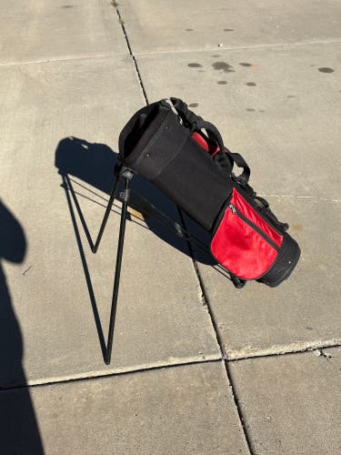 Jr Golf bag: Red Zone, lightweight black and red golf stand bag featuring built-in folding metal leg